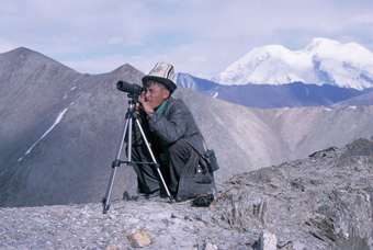 Our guide in Tajikistan scans the terrain for Marco Polo sheep. The Mustagh Ata massif across the border in China is in the: background. Photograph from Tibet Wild by George B. Schaller. Reproduced by permission of Island Press.
